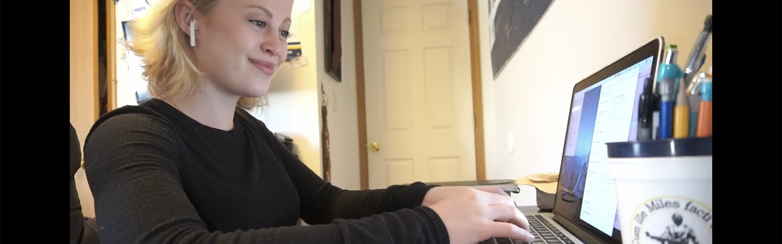 A student working on a laptop while sitting at a desk.